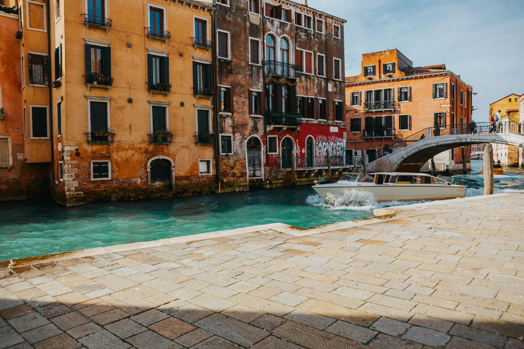 Venetian canal with a boat and historic buildings, shown in 3D depth